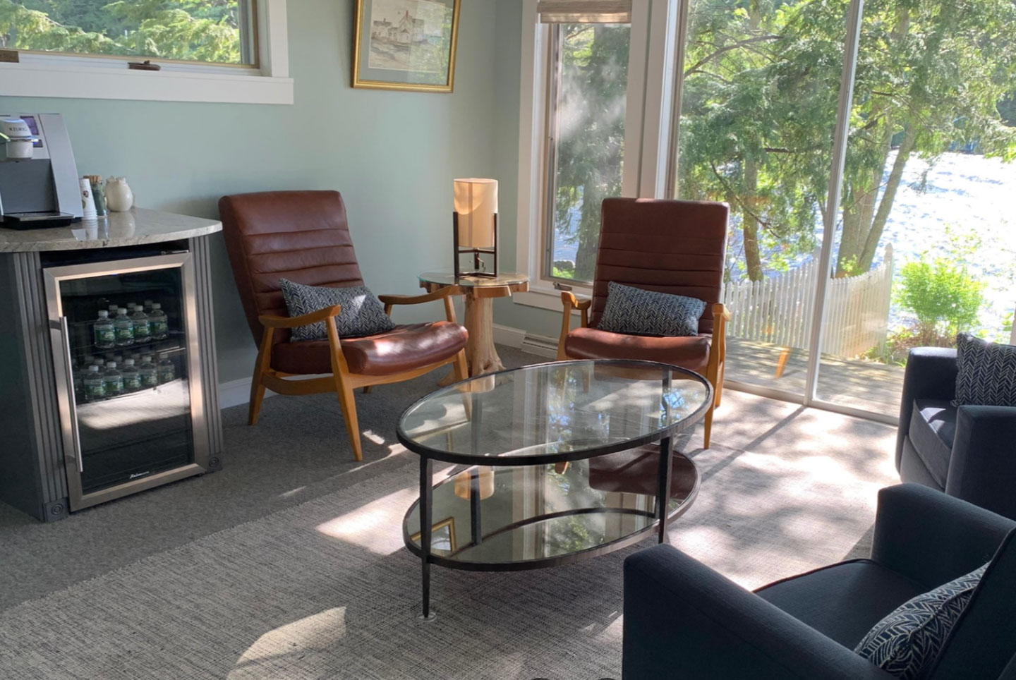 The image depicts a well-furnished living room with a large window providing natural light.